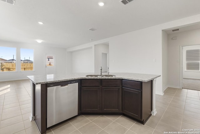 kitchen featuring dark brown cabinetry, sink, a center island with sink, dishwasher, and light tile patterned flooring