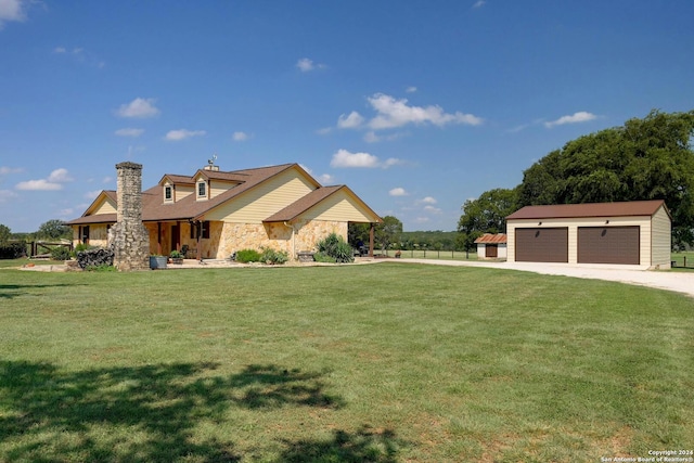 view of front facade with a front yard, a garage, and an outbuilding