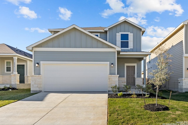 craftsman house with concrete driveway, board and batten siding, a garage, stone siding, and a front lawn