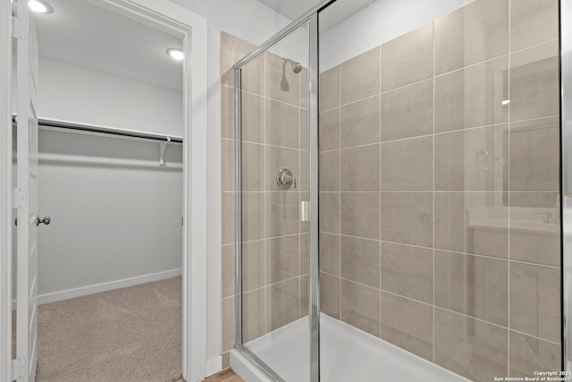 bathroom featuring a shower with door