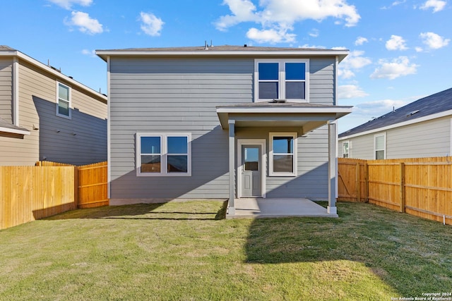 back of house with a patio area and a yard