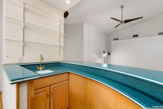 interior space featuring ceiling fan, visible vents, vaulted ceiling, and a sink