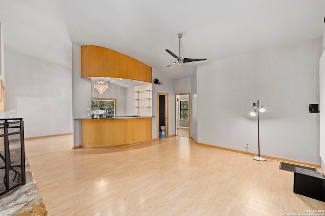 unfurnished living room with a ceiling fan, lofted ceiling, baseboards, and light wood finished floors