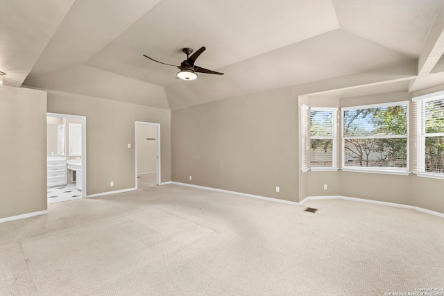 interior space with light carpet, visible vents, baseboards, and lofted ceiling