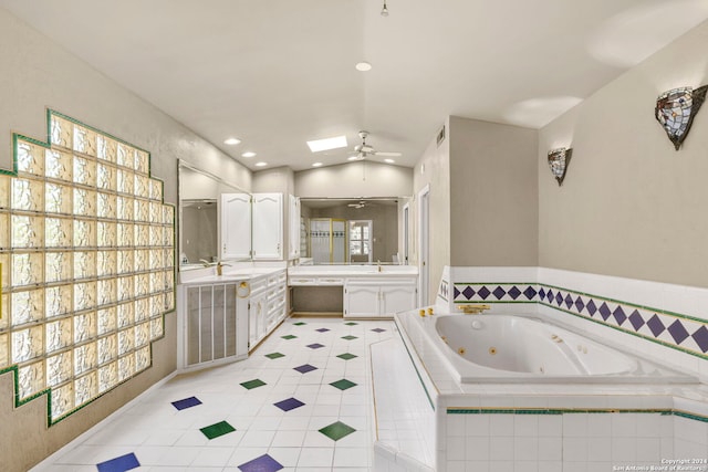 full bath with recessed lighting, a ceiling fan, vanity, vaulted ceiling with skylight, and a whirlpool tub