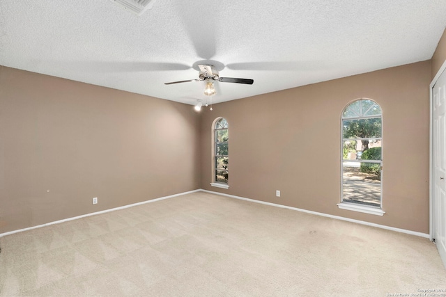 empty room featuring visible vents, baseboards, light colored carpet, and a healthy amount of sunlight