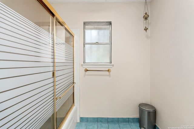 bathroom with tile patterned flooring and combined bath / shower with glass door