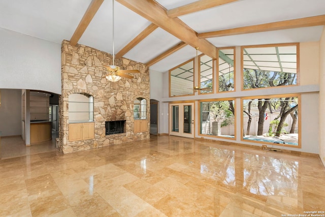 unfurnished living room with high vaulted ceiling, beamed ceiling, a ceiling fan, and a stone fireplace