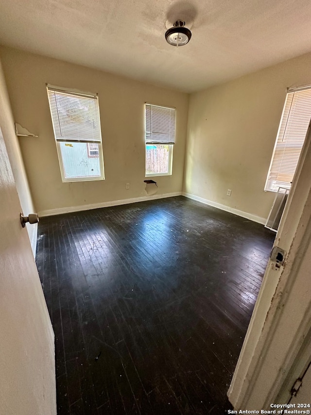 spare room with hardwood / wood-style flooring and a textured ceiling