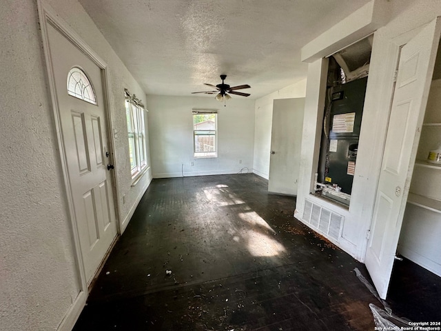 entrance foyer featuring ceiling fan, a textured ceiling, and heating unit