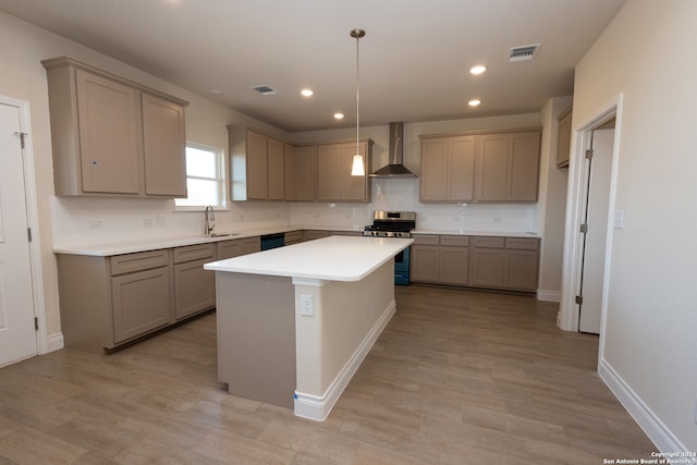 kitchen featuring a kitchen island, wall chimney exhaust hood, tasteful backsplash, stainless steel range with gas stovetop, and decorative light fixtures