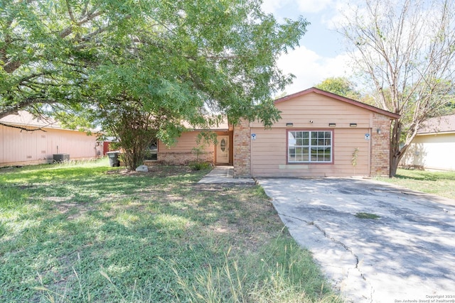 ranch-style home featuring driveway, brick siding, and a front yard