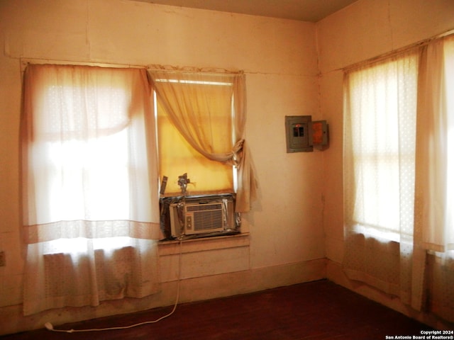 spare room featuring cooling unit, hardwood / wood-style floors, and electric panel