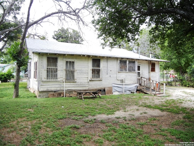 rear view of house featuring a yard