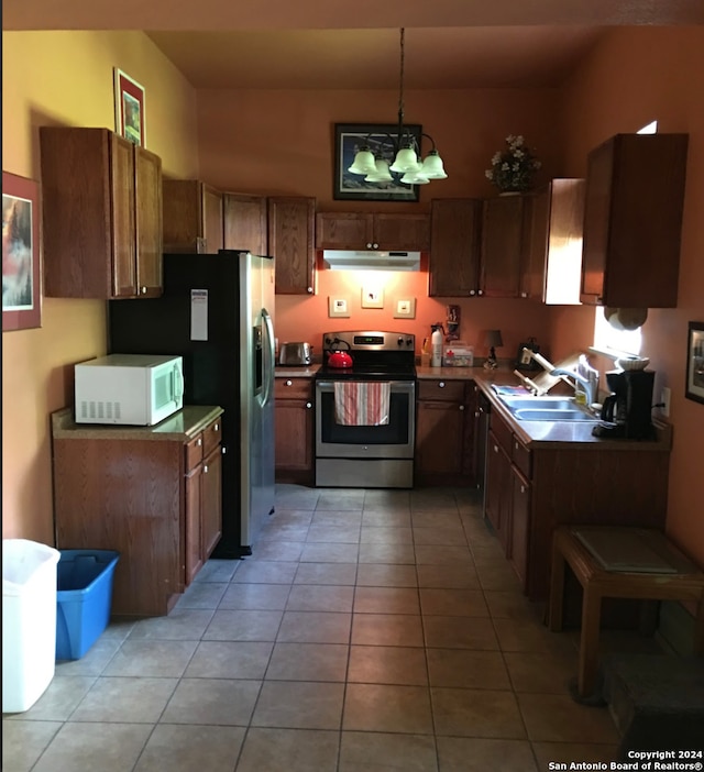 kitchen with sink, electric stove, light tile patterned floors, and hanging light fixtures