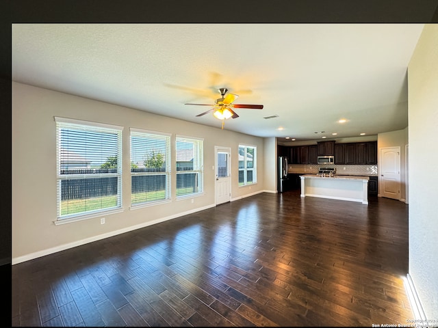 unfurnished living room featuring ceiling fan and dark hardwood / wood-style flooring