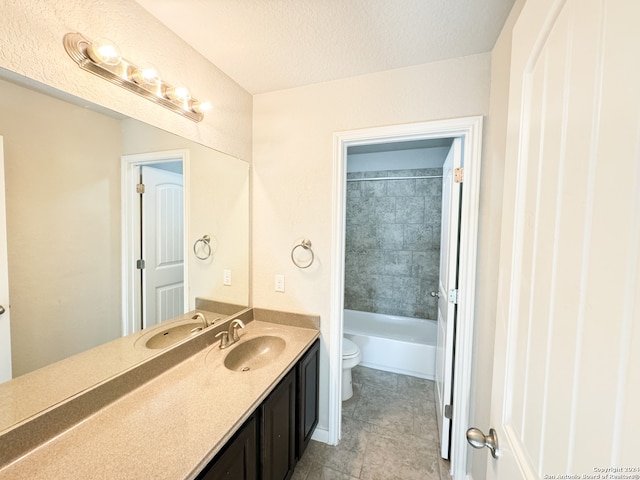 full bathroom featuring vanity, tile patterned floors, a textured ceiling, toilet, and tiled shower / bath combo