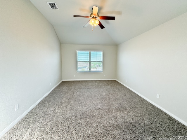 carpeted spare room featuring ceiling fan and vaulted ceiling