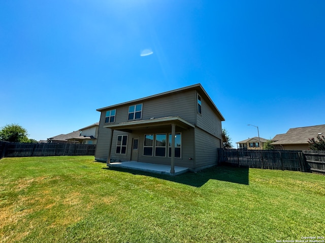 rear view of house featuring a patio and a lawn