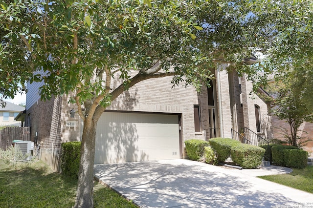 view of front of home with a garage and central AC