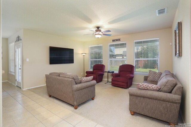 tiled living room featuring ceiling fan and a textured ceiling