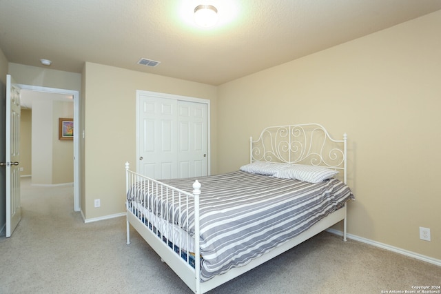 bedroom with a closet and light carpet