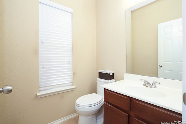 bathroom with toilet, vanity, and tile patterned floors