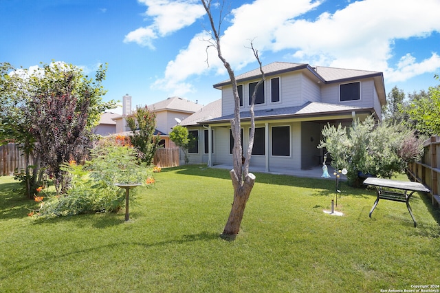 rear view of property featuring a lawn and a patio