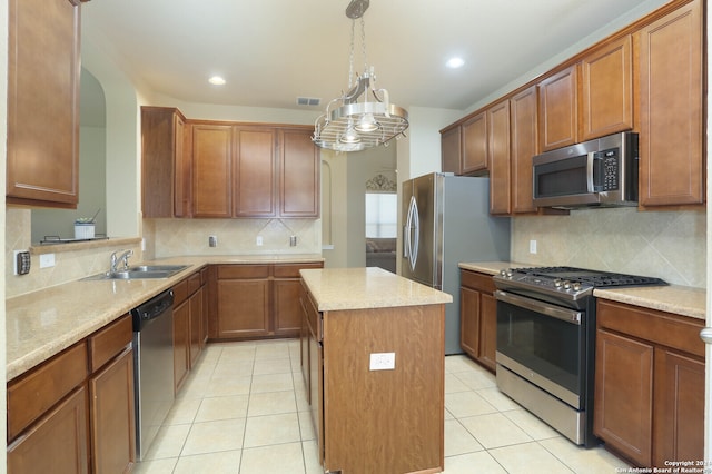 kitchen with backsplash, appliances with stainless steel finishes, sink, a chandelier, and a center island