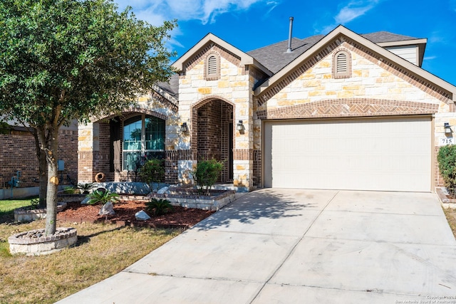 french provincial home featuring an attached garage, brick siding, a shingled roof, concrete driveway, and stone siding