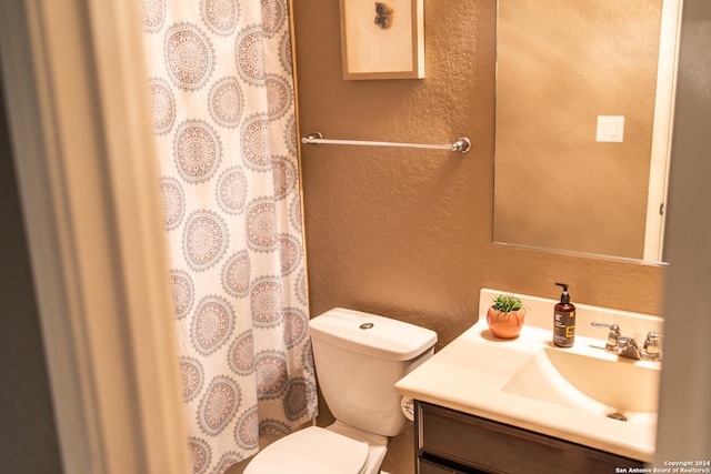 bathroom with a shower with shower curtain, toilet, and vanity