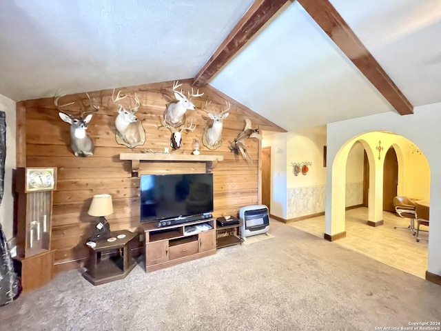 carpeted living room featuring wood walls and lofted ceiling with beams