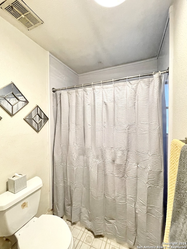 bathroom with toilet and a shower with curtain