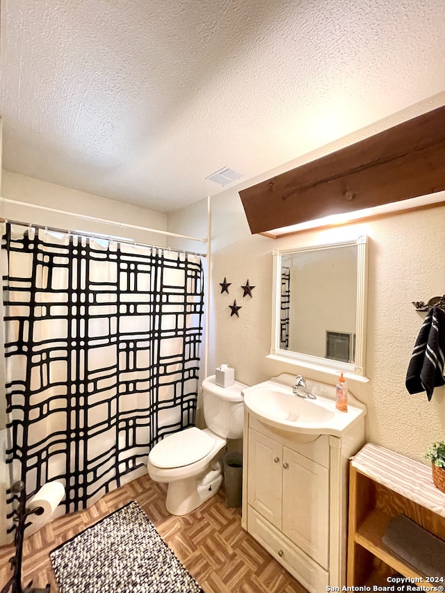 bathroom featuring vanity, parquet flooring, toilet, and a textured ceiling