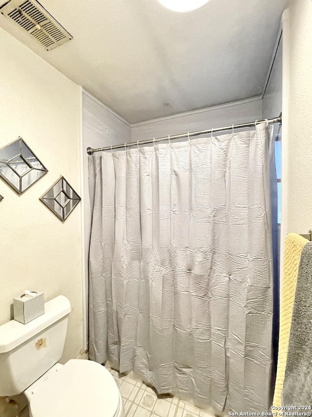 bathroom with toilet and tile patterned flooring