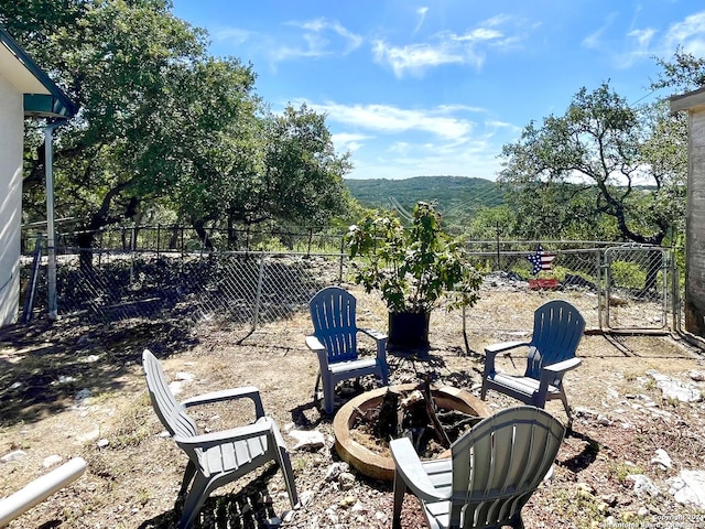 view of patio with a mountain view and an outdoor fire pit