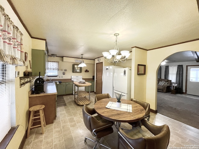 dining space featuring an inviting chandelier, sink, a textured ceiling, and a wealth of natural light