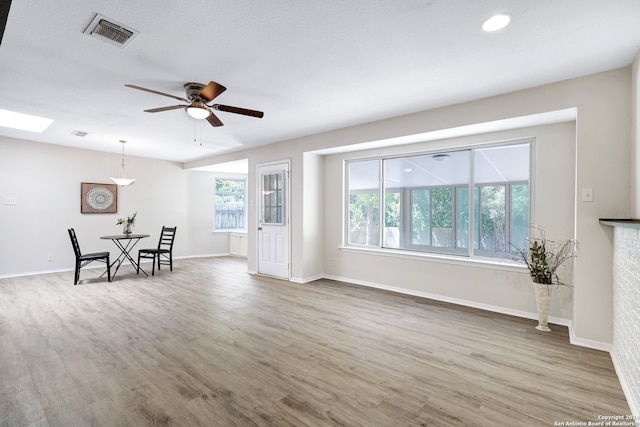 living room with hardwood / wood-style floors, a wealth of natural light, ceiling fan, and a textured ceiling