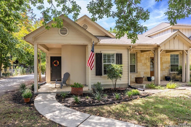 view of front of home featuring stone siding, a shingled roof, and fence