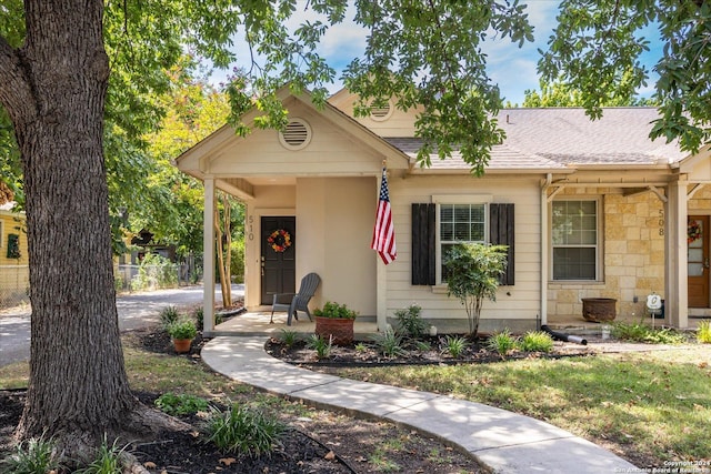 view of front of home featuring stone siding and a shingled roof