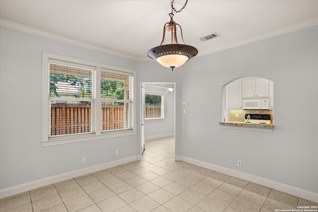 empty room with crown molding and light tile patterned flooring