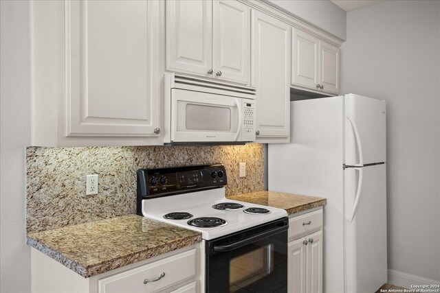 kitchen with decorative backsplash, white appliances, and white cabinetry