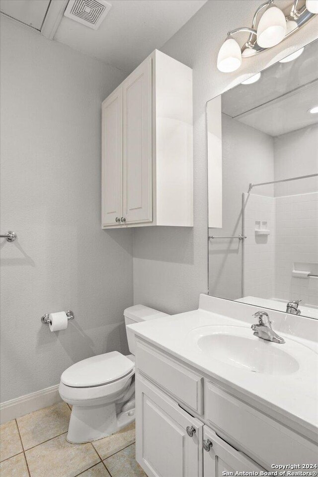 bathroom with toilet, walk in shower, tile patterned flooring, and vanity