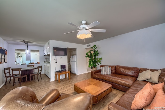 living room with ceiling fan and light wood-type flooring