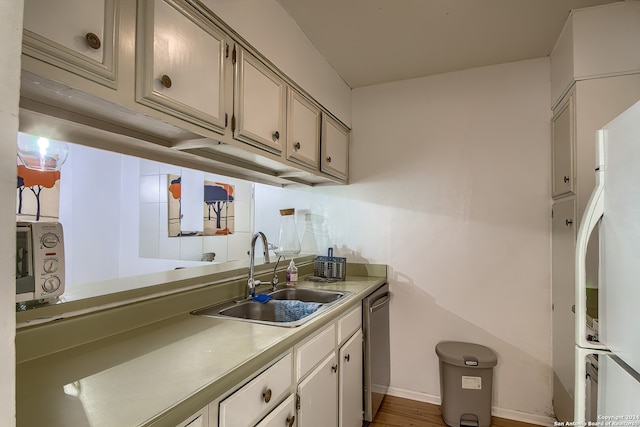 kitchen featuring sink, dishwasher, hardwood / wood-style floors, and white fridge