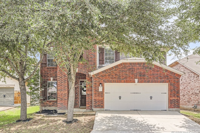 view of front of home with driveway, an attached garage, and brick siding