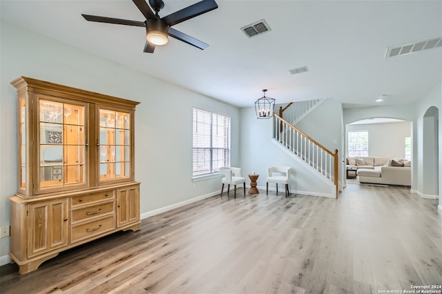 interior space featuring stairway, visible vents, arched walkways, and light wood-style floors