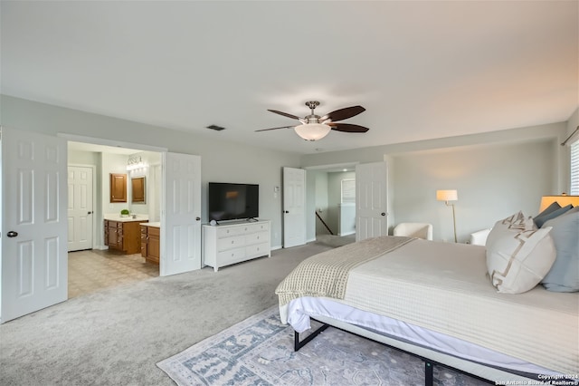 bedroom featuring visible vents, ensuite bathroom, a ceiling fan, and light colored carpet