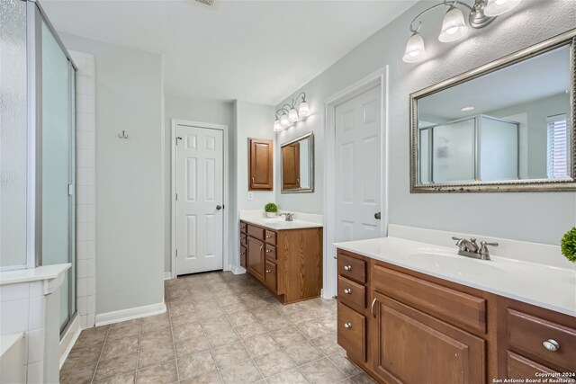 bathroom featuring vanity, tile patterned floors, and walk in shower