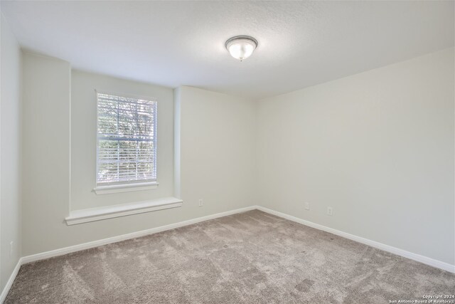 carpeted empty room with baseboards